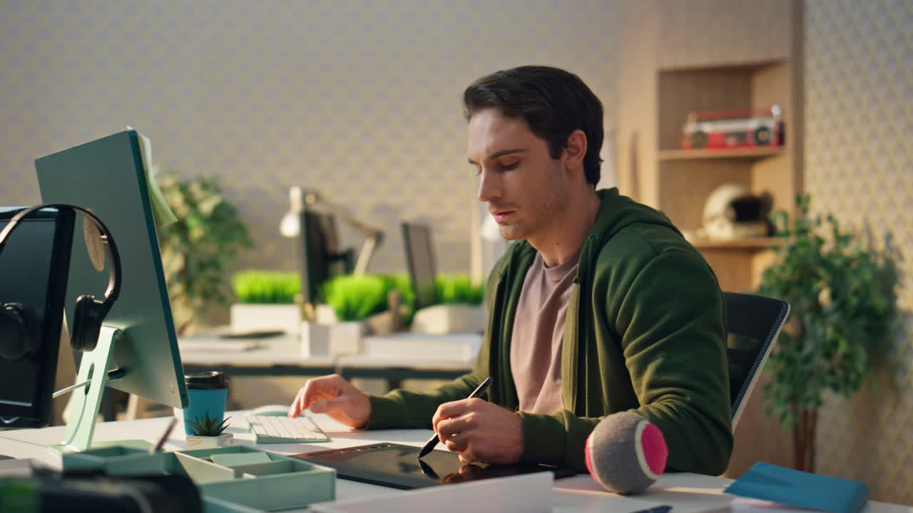 Pensive freelancer watching screen at office. Graphic designer holding stylus