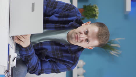 Vertical-video-of-Home-office-worker-man-looking-nervously-at-camera.