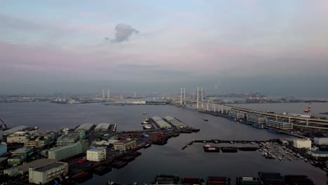 Morgendämmerung-über-Geschäftigem-Hafen-Mit-Hängebrücke-Und-Skyline-Der-Stadt