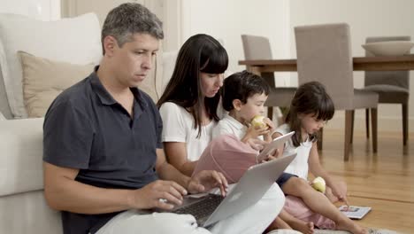 pareja de padres enfocados usando computadoras