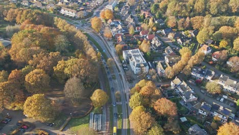 aerial of busy main road in a peaceful town on a sunny autumn day