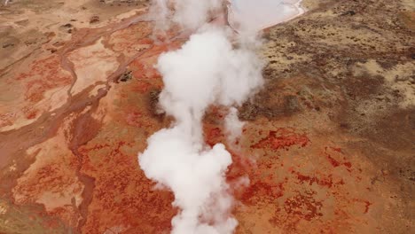 steam rising from the vivid gunnhuver hot springs in iceland, aerial view