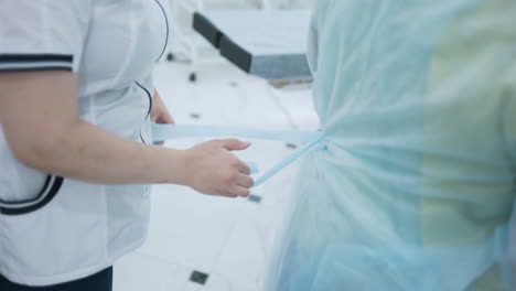 nurse assisting a patient with protective gown
