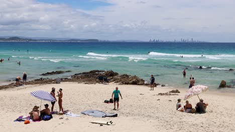 personas disfrutando de varias actividades en una playa soleada