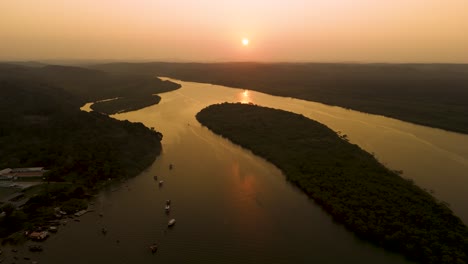 aerial of a river with tropical forest island at golden hour, rio de contas, brazil