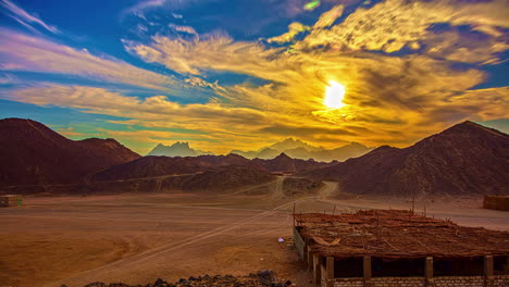 Clouds-Moving-On-Sunny-Blue-Sky-Over-Sandy-Terrain-With-Hills-And-Unfinished-Building-Structure