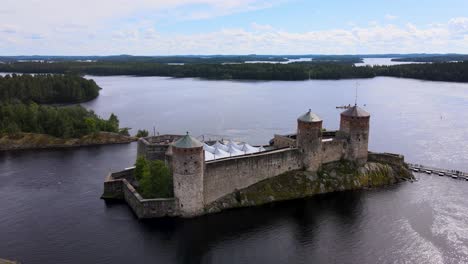 rotating aerial drone shot of medieval castle olavinlinna on a beautiful summer day