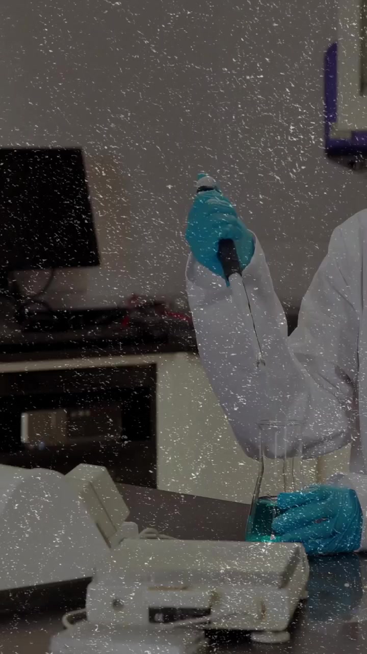 Video vertical: Técnica de laboratorio presionando el émbolo de una pipeta sobre un vaso de precipitados, moviendo líquido azul verdoso para un ensayo.