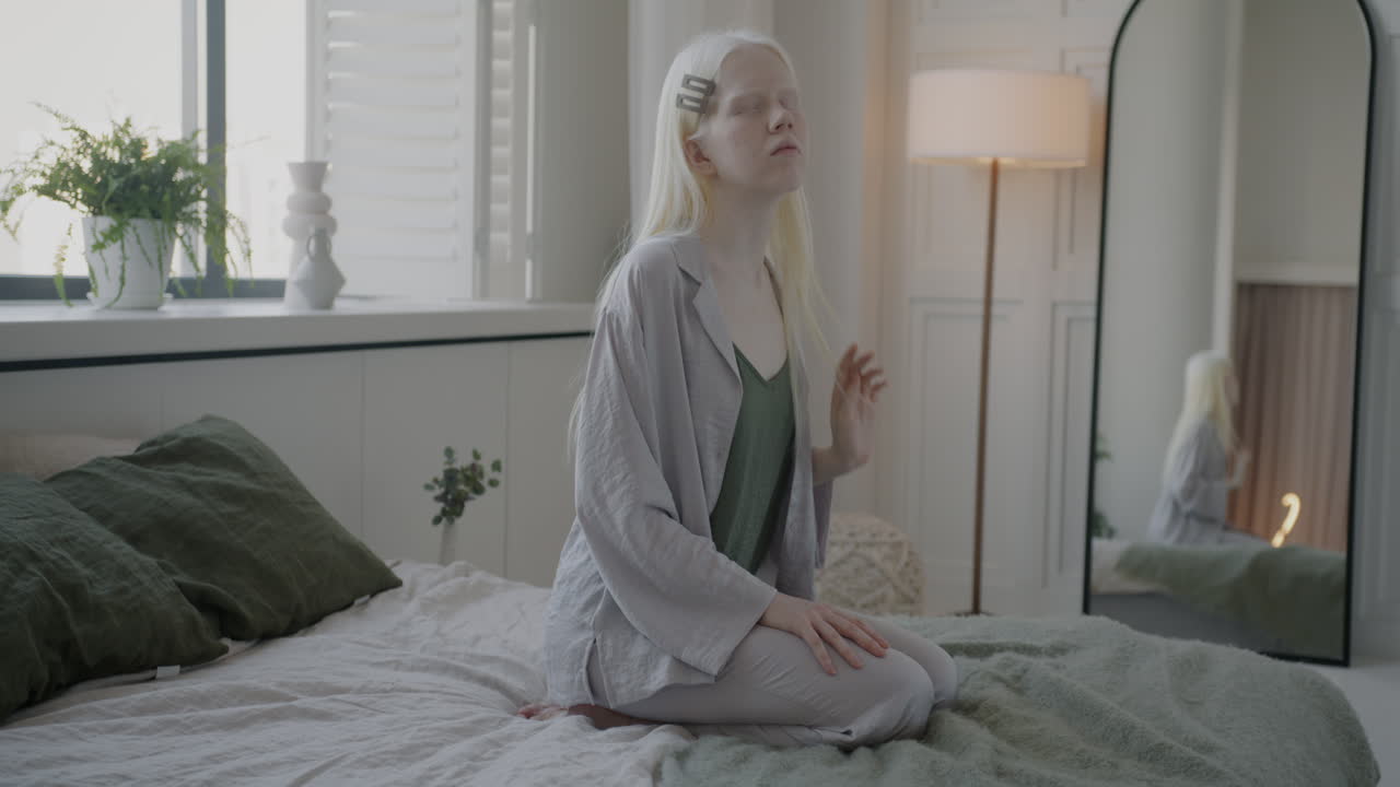 Blonde Girl in Pajamas Sitting on a Bed