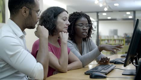 Focused-students-working-over-new-project-at-library