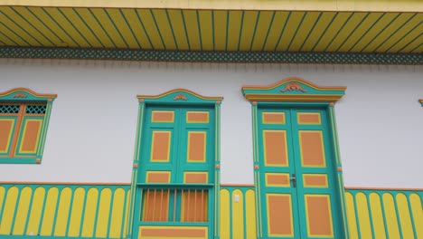 POV-shot-in-front-of-decorated-homes-with-vibrant-windows-and-doors,-in-Colombia