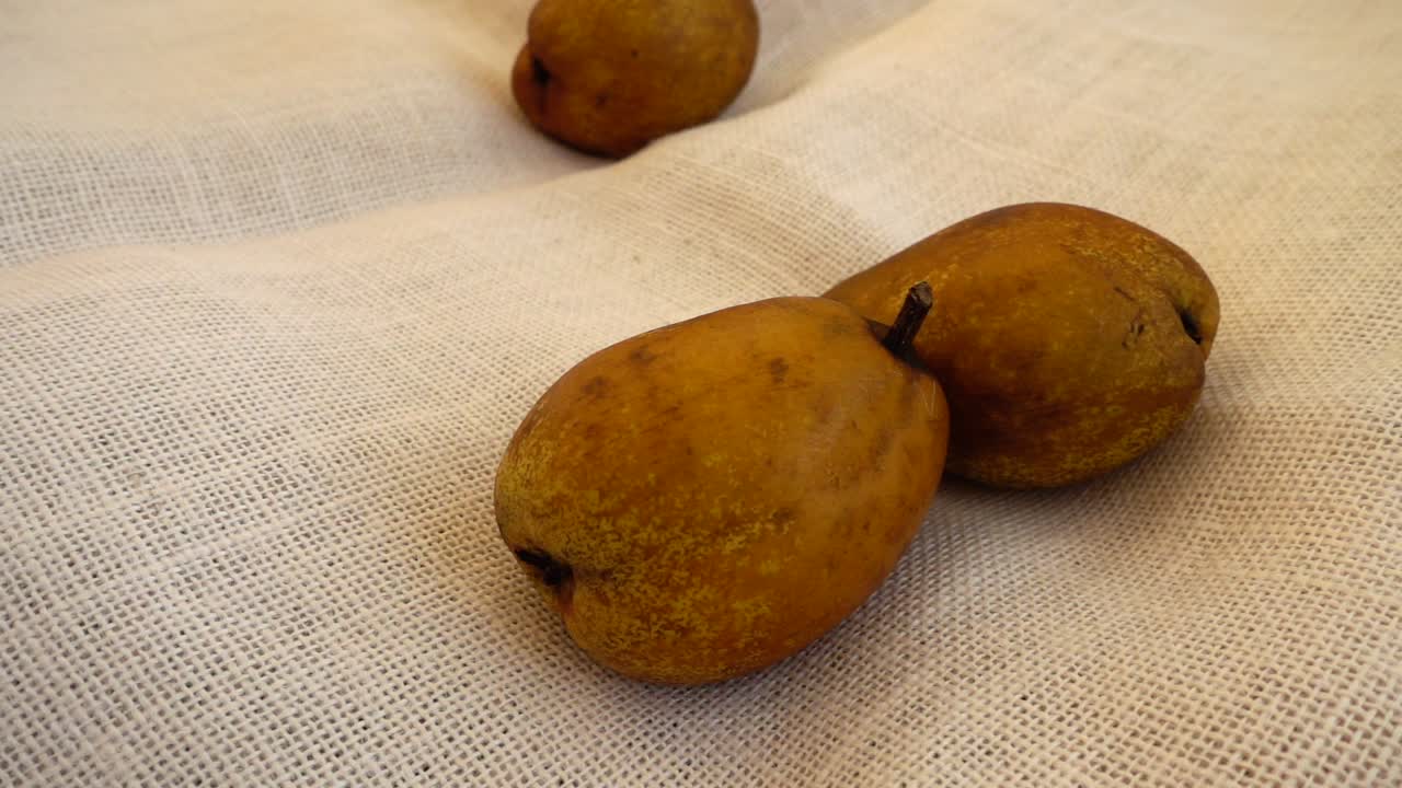 Pere fresche che cadono su una superficie di tessuto con texture