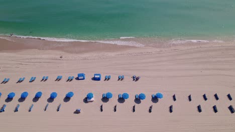 impresionante vista de sillas de playa y paraguas volando sobre la arena y el agua azul de la playa azul cielo palmeras ft