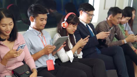 young people using mobile phone in public underground train