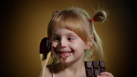 Niña-Sonriente-Alegre-Con-La-Cara-Sucia-De-Chocolate-Derretido-Sobre-Fondo-Oscuro-En-El-Estudio