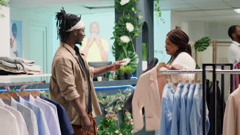 couple buying clothes on racks in store