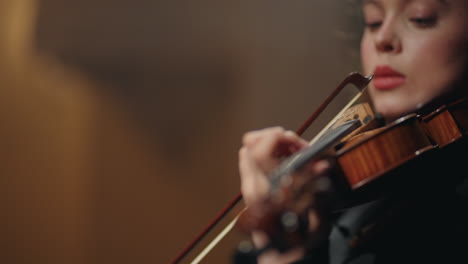 young woman fiddler is playing violin in philharmonic hall closeup portrait of female violinist