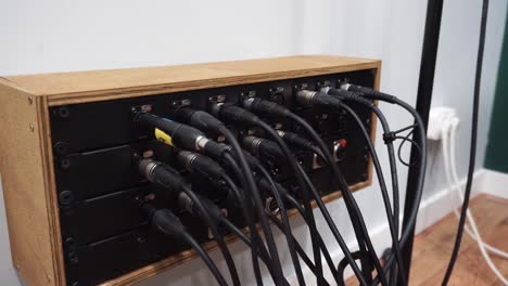 primer plano de la mano del hombre enchufando el micrófono xlr en el conector del amplificador