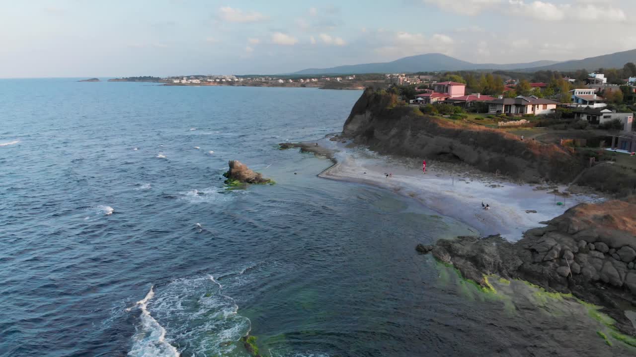 toma panorámica aérea, drones vuelan alrededor de acantilados costeros y casas de playa