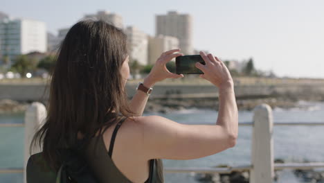 Porträt-Einer-Schönen,-Eleganten-Frau,-Die-Am-Sonnigen-Strand-Ein-Foto-Mit-Dem-Telefon-Macht