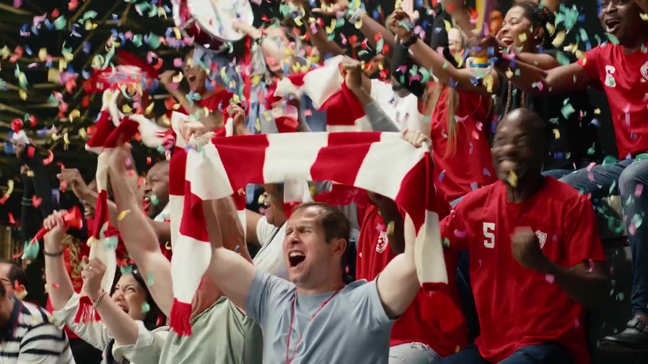 Entusiastas aficionados al fútbol celebrando con confeti en las gradas del estadio