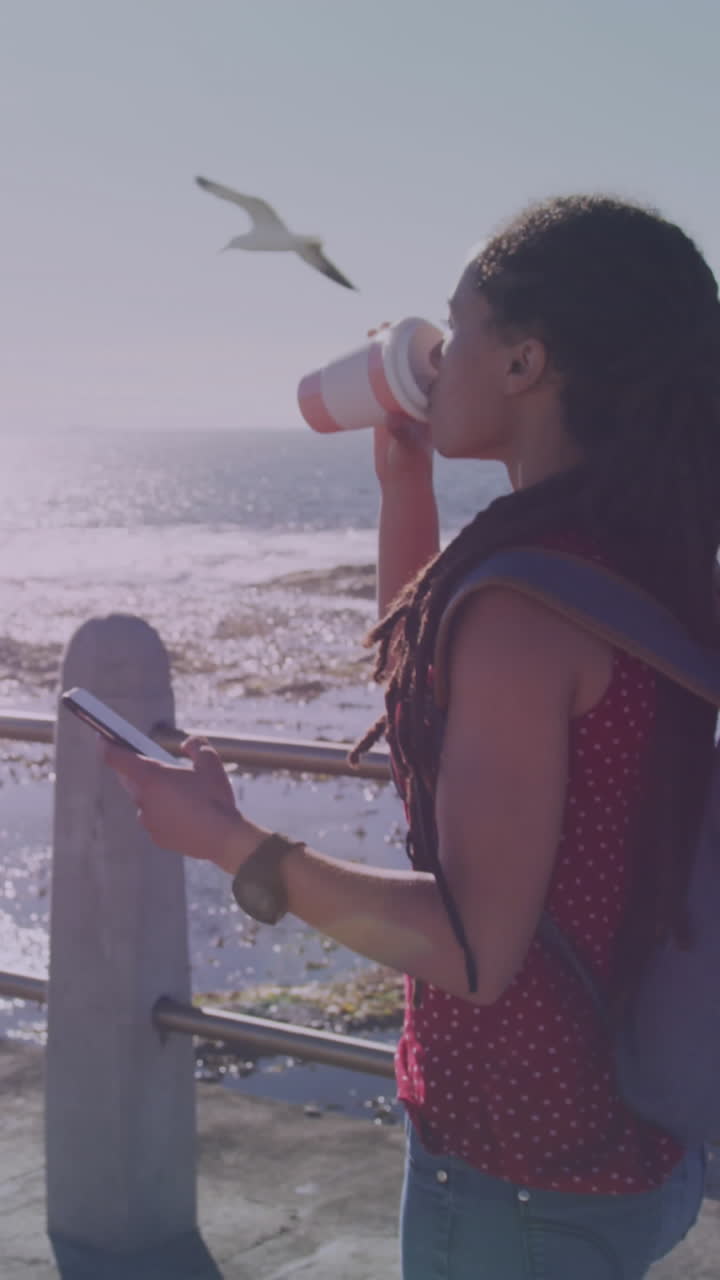 икона кофейной чашки заполняется против афроамериканской женщины, пьющей кофе на набережной.