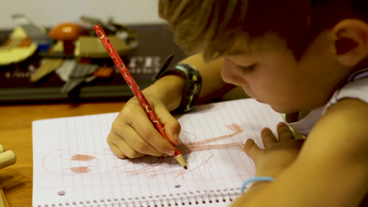 niño dibujando una imagen en el cuaderno escolar
