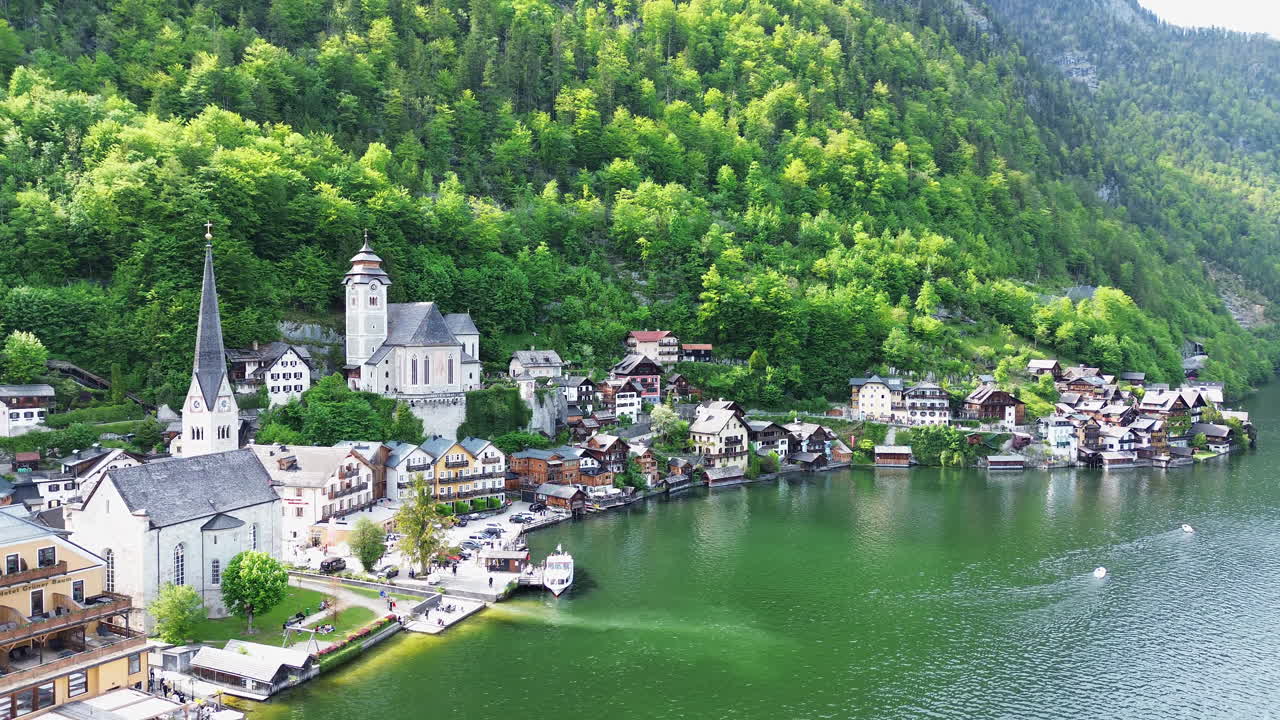 Hallstatt Town Along The Lake In Daytime With Verdant Forest In The Mountain In Austria. - aerial shot