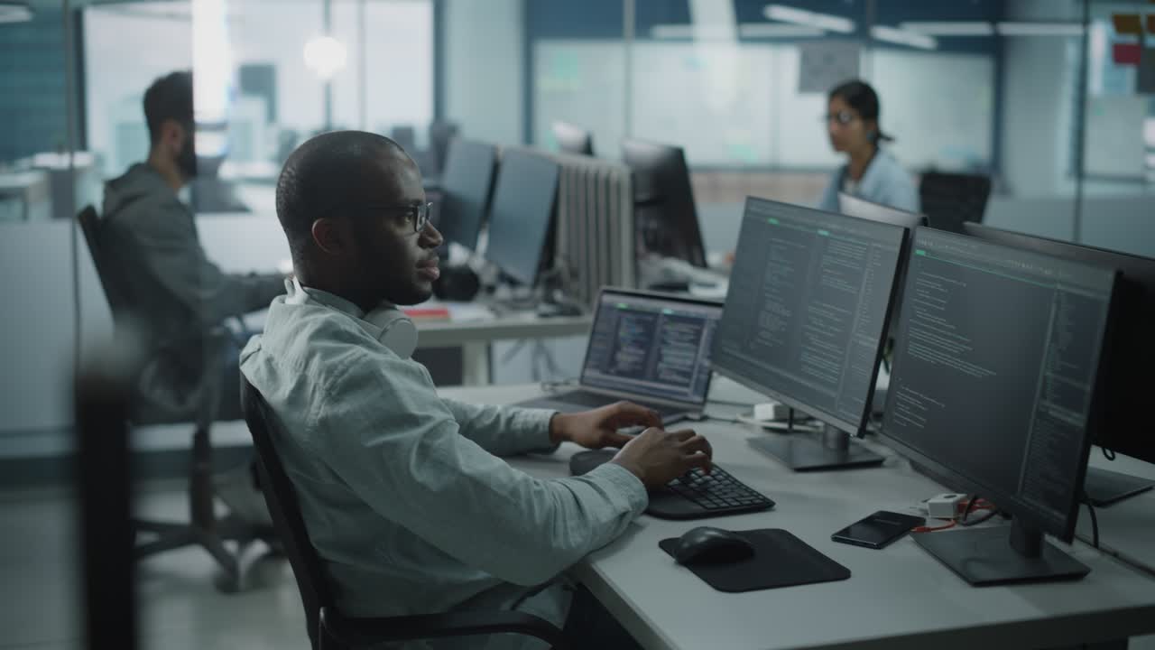 oficina auténtica: entusiasta programador de ti negro comienza a trabajar en una computadora de escritorio. desarrollador de sitios web masculino, ingeniero de software desarrollando aplicaciones, videojuegos. terminal con lenguaje de programación de codificación