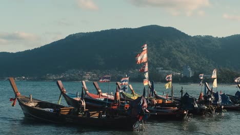 a couple of boats docked at thailand beach during a sunny day