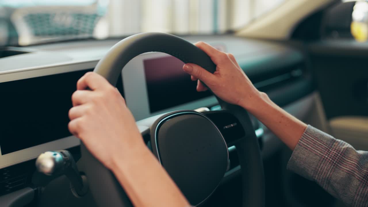 여성의 손이 전기차의 스티어링 에: 차량의 미래를 디자인하는 다시보드, 전기차의 에 있는 여성의 손