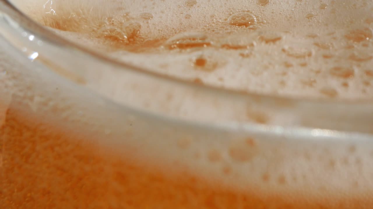 Lebih banyak bir dituangkan ke dalam gelas bir, dan saat terisi penuh, rekaman menjadi kurang tajam, secara visual menunjukkan berbagai tahapan konsumsi alkohol berlebihan