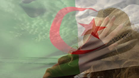 wearing hat with algerian flag, person standing against cloudy sky background