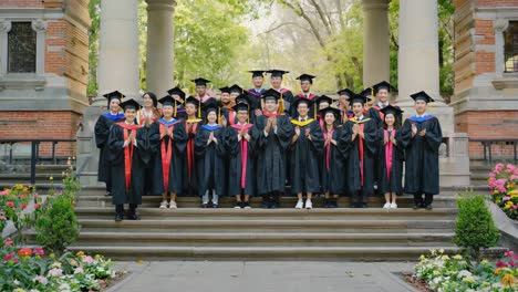 large group of graduates in caps and gowns on university steps