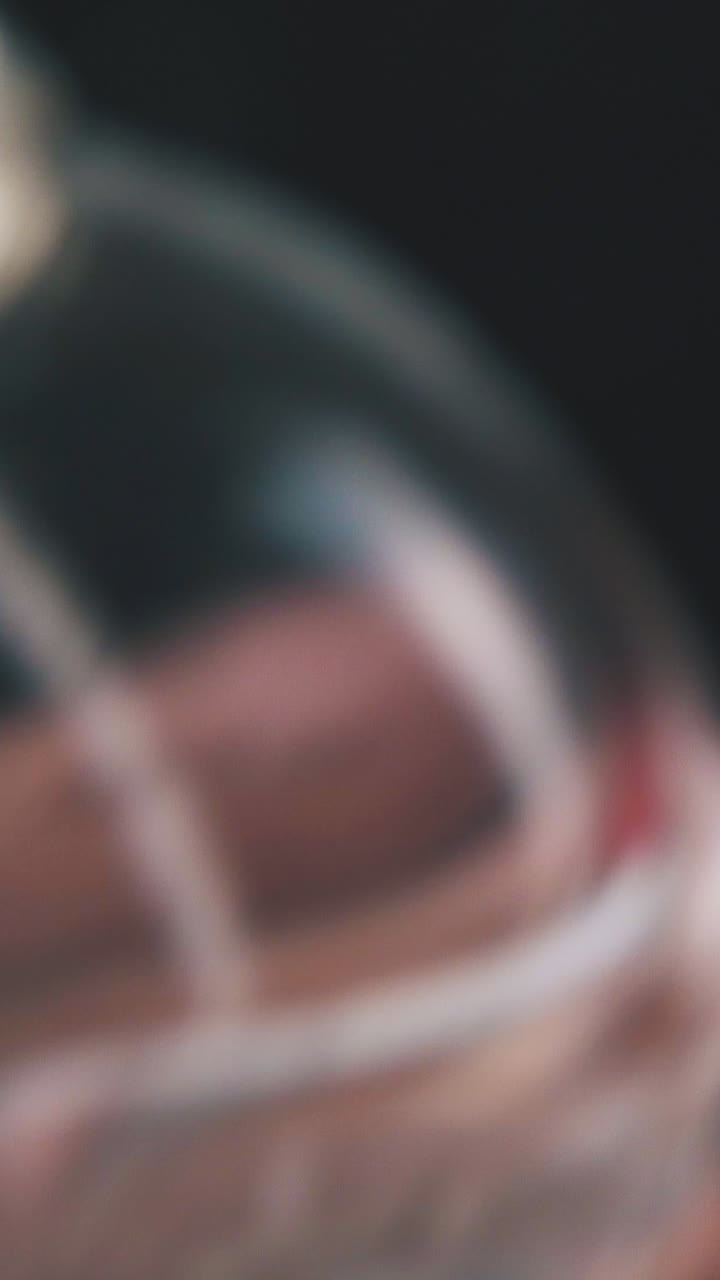 person puts plastic cap on women perfume water little bottle on dark background extreme close view
