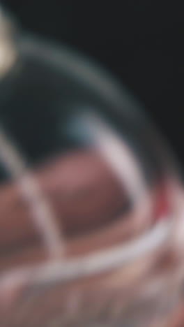 person puts plastic cap on women perfume water little bottle on dark background extreme close view