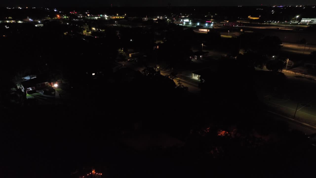 Night scene in american neighborhood with service Station and restaurants in Background. Aerial wide shot. Small american town in Florida, USA.