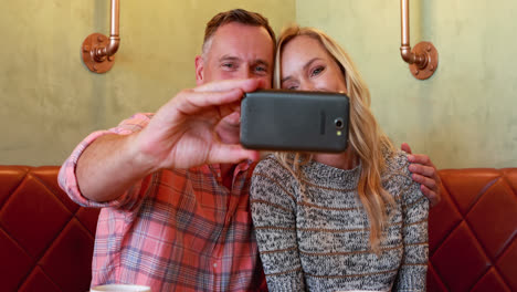 Couple-taking-selfie-on-mobile-phone-in-restaurant-4k