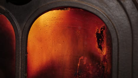 flames through gritty cast iron stove glass