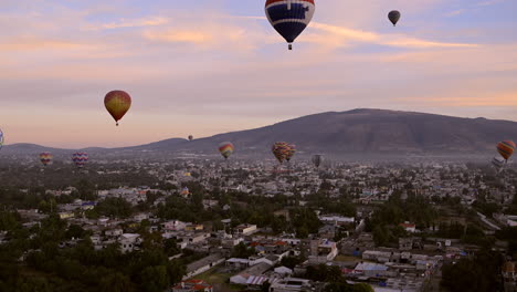 dozens of hot air balloons soar over the city of teotihuacan in mexico