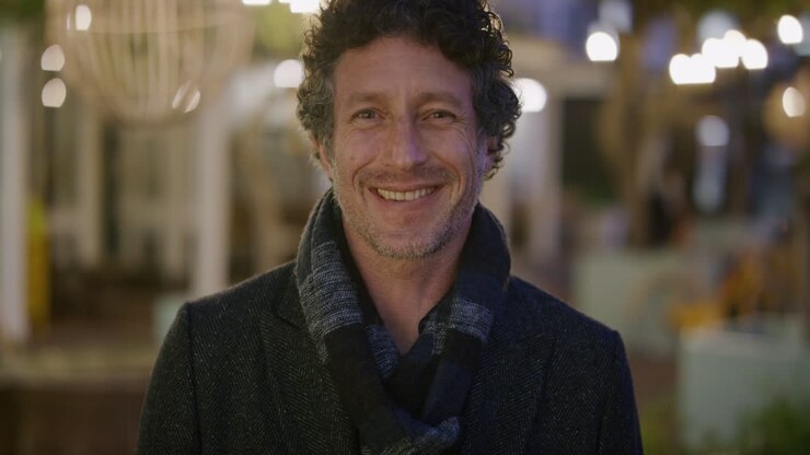 ritratto attraente uomo d'affari maturo sorridente che si gode una serata urbana rilassata in città vestito di moda calda slow motion