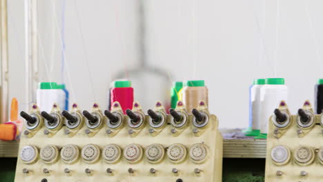 workshop inside multi colored reel thread set up in automated textile factory, showing rows of industrial looms and machinery for weaving yarn into textiles