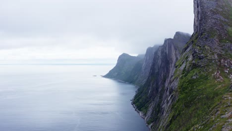towering rocky mountains of segla on seafront in senja island, norway