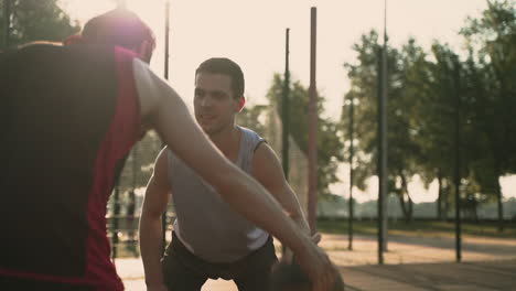 primer plano de un hábil jugador de baloncesto haciendo un regate cruzado contra su defensor contrario en una cancha de baloncesto al aire libre