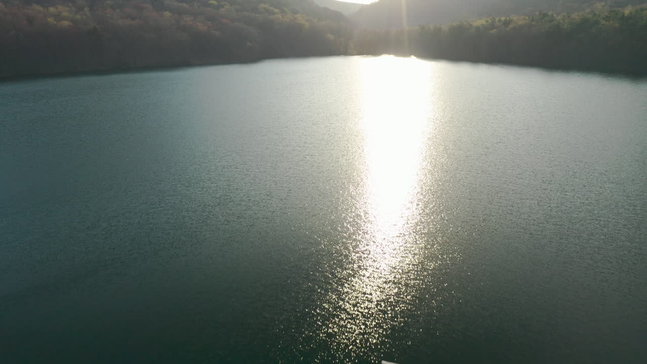 일몰 시 푸른 산과 나무로 둘러싸인 숲 호수 위로 영화 공중 팬