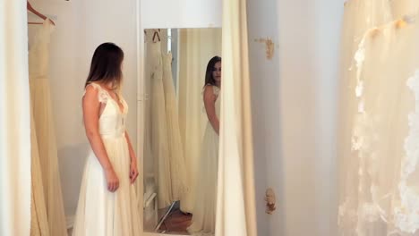 beautiful woman trying on wedding dress in a shop