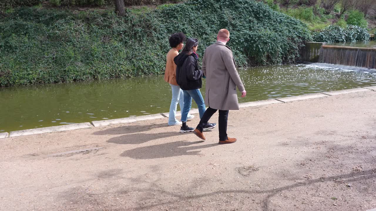Gente paseando por un sendero cerca de un río en un parque