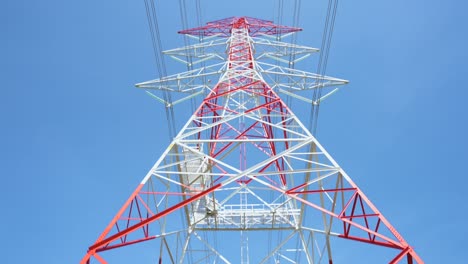 4k prores of  red and white color high voltage pole and blue sky