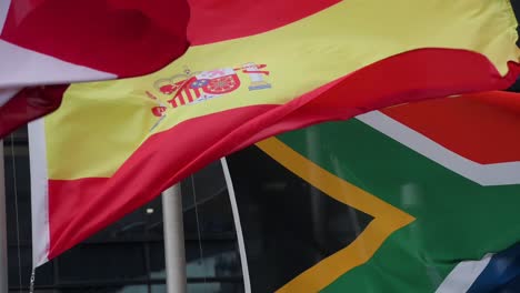 se ven banderas nacionales en cámara lenta de españa, sudáfrica, suiza y arabia saudita ondeando al viento en hong kong.