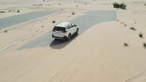 white suv driving through desert roads